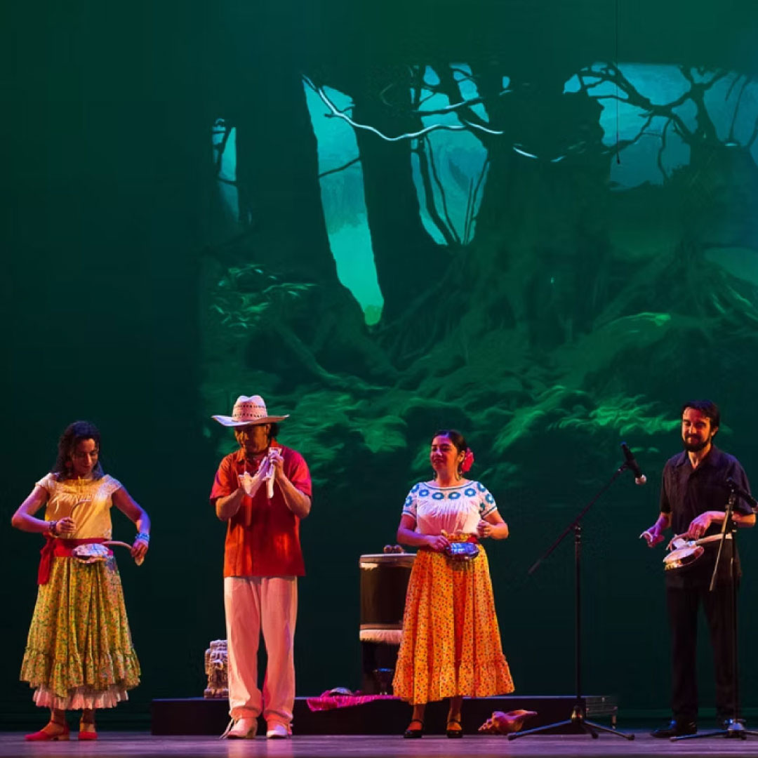 trekking performers stand onstage holding instruments during a production of trekking mexico