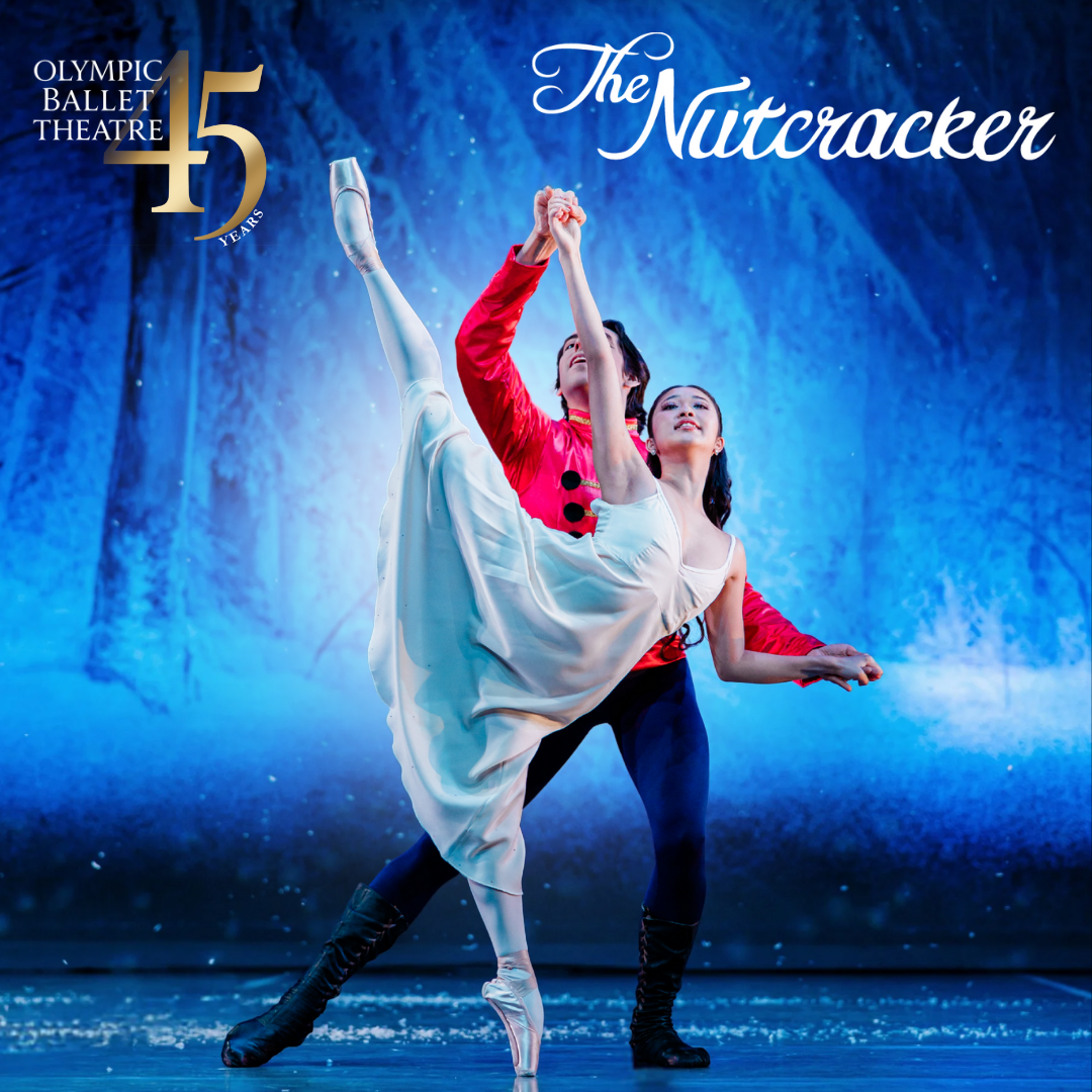 a male ballerina wearing a red shirt and black tights poses with a female ballerina on pointe with one leg up in the air. she wears a pale blue gown and they stand on stage with a snowy backdrop behind them