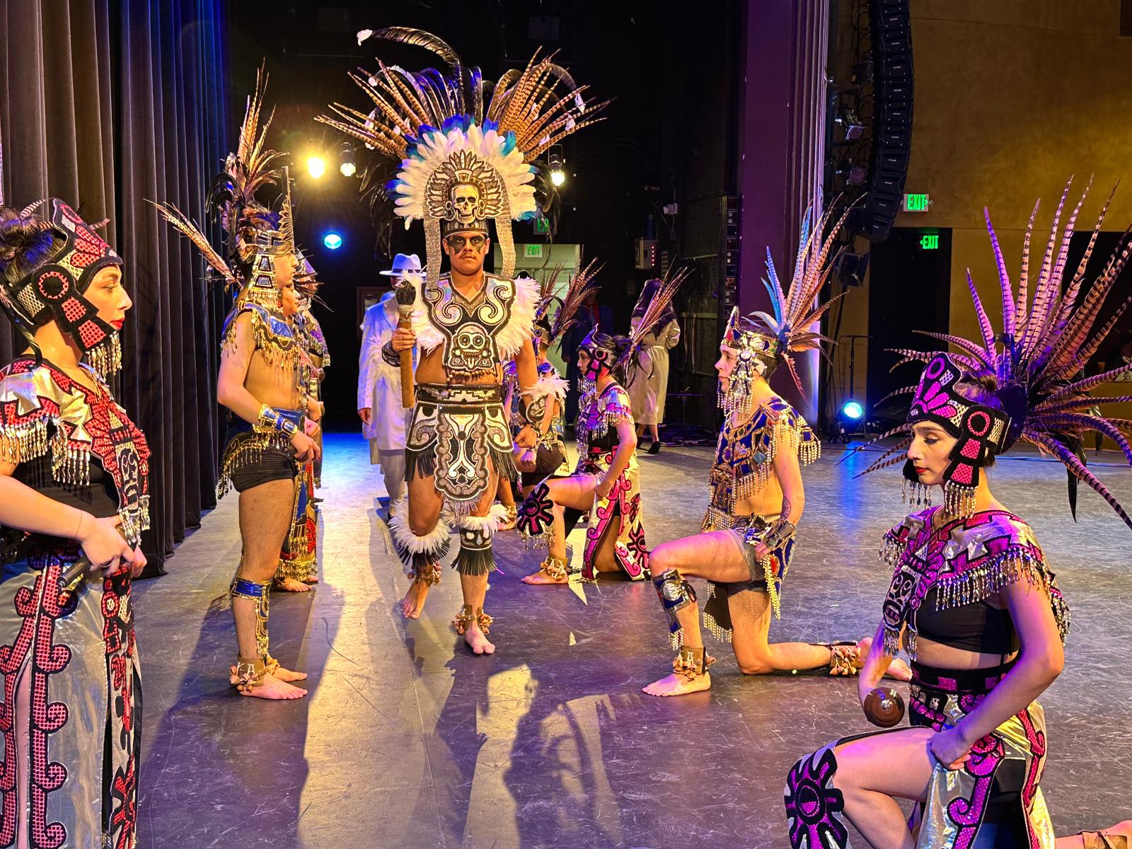 the lead performers from under the tangle stand back to back, smiling, with their hands clasped